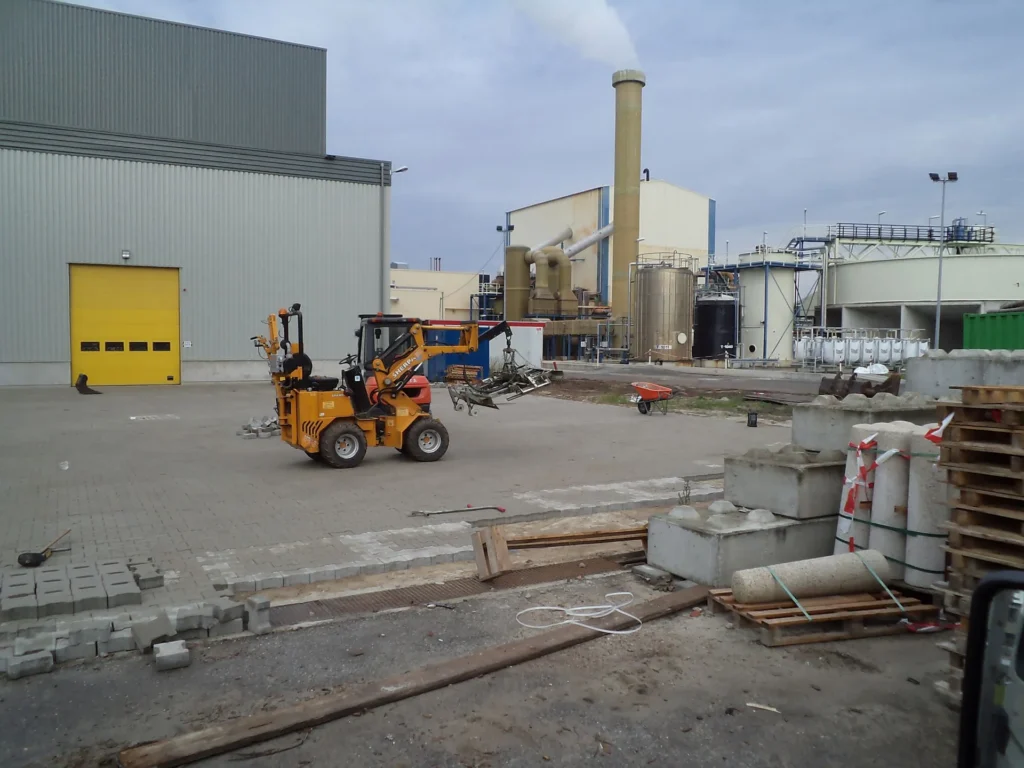 Shovel en pallets klinkers op een bedrijfsterrein in aanleg