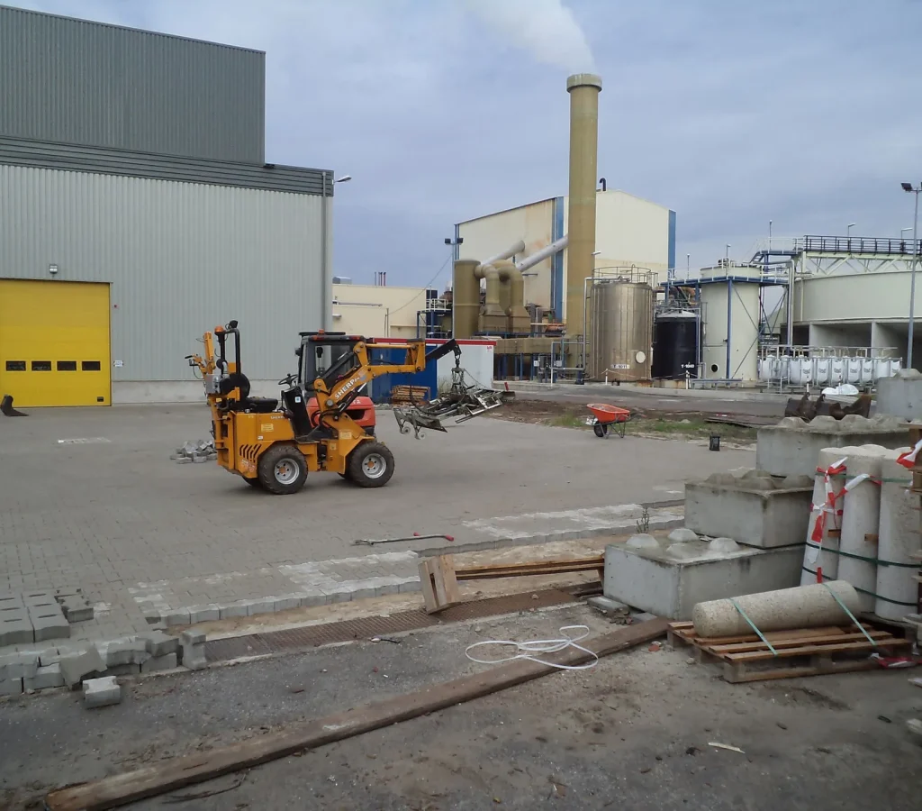 Shovel en pallets klinkers op een bedrijfsterrein in aanleg